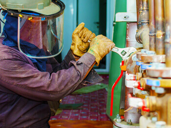 Plumber using a wrench to tighten pipes